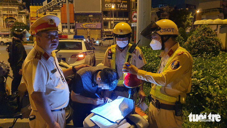 Ông C. ký vào biên bản xử phạt vi phạm nồng độ cồn - Ảnh: MINH HÒA